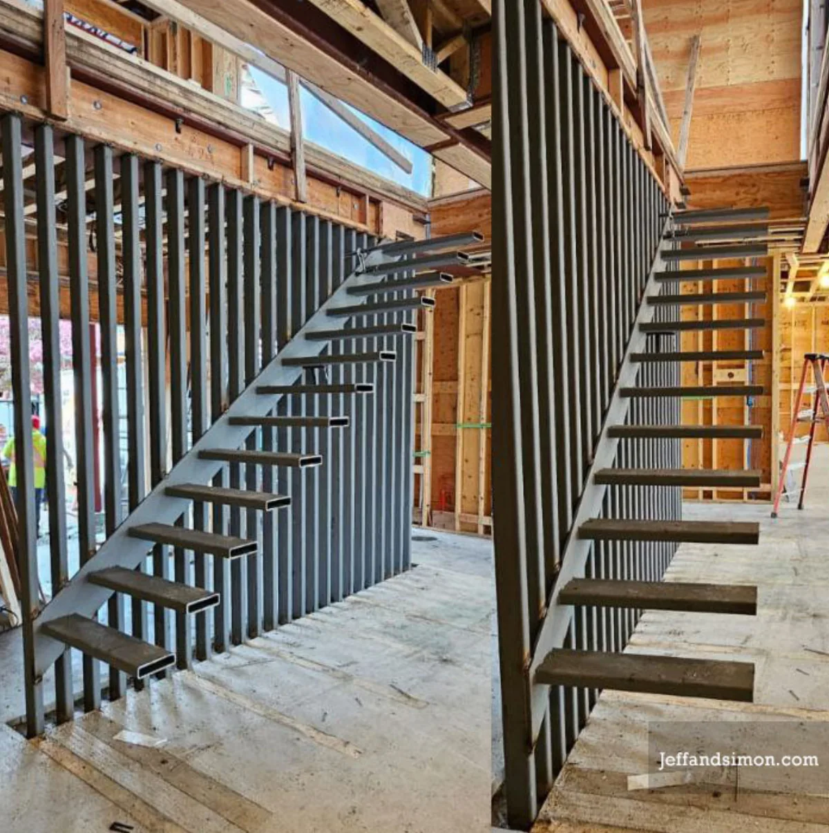 Custom steel staircase under construction — double stringer frame with iron picket guard by Vancouver Stairs