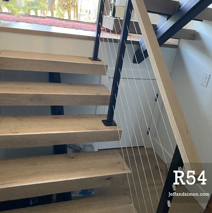 Mono stringer staircase with cable railing and oak treads in a West Coast Modern home